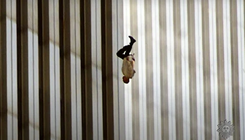 Person in dark clothing suspended mid-fall against vertical striped background.