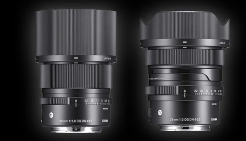 Two telephoto camera lenses with vertical ribbed barrels displayed side-by-side against a dark background.