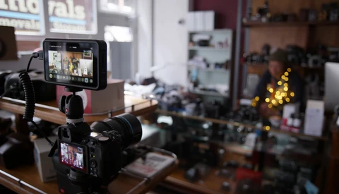 Professional camera rig with external monitors mounted on a workbench in a production studio.