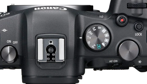 Top view of a mirrorless camera body showing the hot shoe, mode dial, and control buttons.