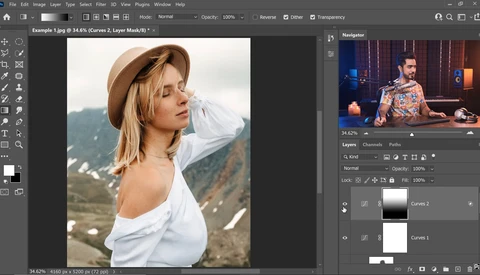 Woman in white shirt and tan hat posing in mountainous landscape during golden hour.