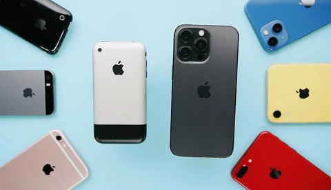 Collection of iPhones in various colors and generations arranged on a light blue background.