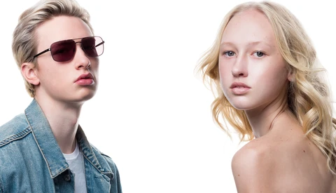 Two blonde individuals with neutral expressions against white background, one wearing sunglasses and denim jacket.