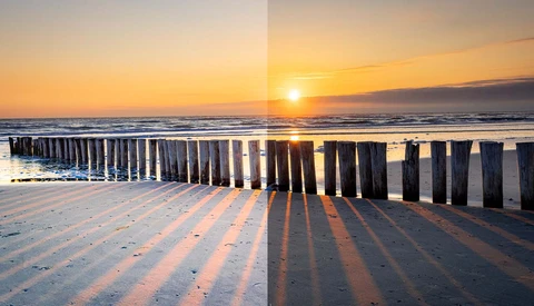 Wooden pier pilings casting long shadows on a beach at sunrise over calm ocean waters.