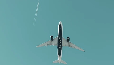 Aircraft shot from directly below against clear blue sky, showing symmetrical top-down composition.