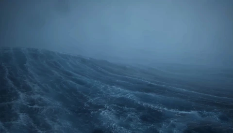 Mountainous landscape shrouded in dense fog and mist under overcast skies.