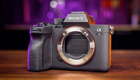 Sony α7 mirrorless camera body displayed from front, showing open mirror box and copper-colored lens mount ring.