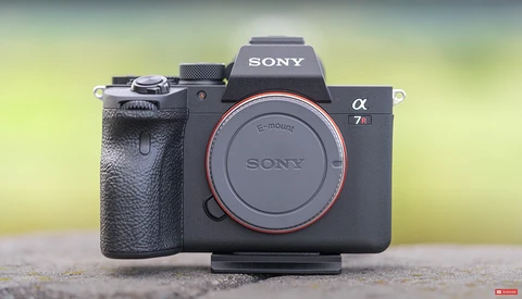 Sony α7 II mirrorless camera body with E-mount displayed against a blurred yellow-green background.