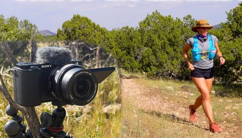 Sony camera on tripod mounted in foreground with trail runner in blue vest jogging on desert path behind.