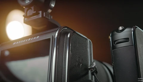 Medium format camera with textured leather body and bright studio light in background.