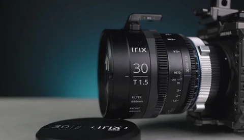Irix 30mm T1.5 cinema lens mounted on a camera body against a teal and gray background.