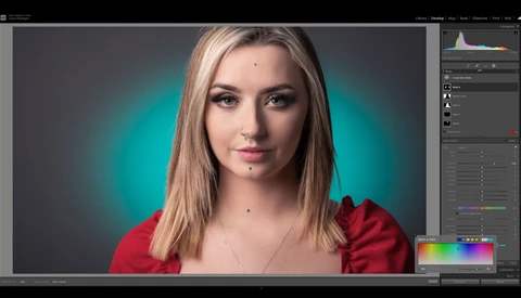 Portrait of a woman with long blonde hair wearing a red top against a teal gradient background.