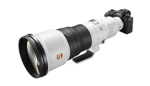 Sony mirrorless camera mounted with a large white telephoto lens featuring an orange G badge.