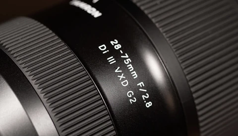Close-up of a camera lens barrel showing focal length and aperture markings in macro detail.