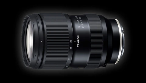 Tamron zoom lens with black barrel and white text markings shown against a dark background.