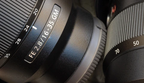 Close-up of camera lenses showing focal length markings and aperture specifications.
