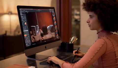 Photographer editing interior images on a desktop computer using professional editing software.