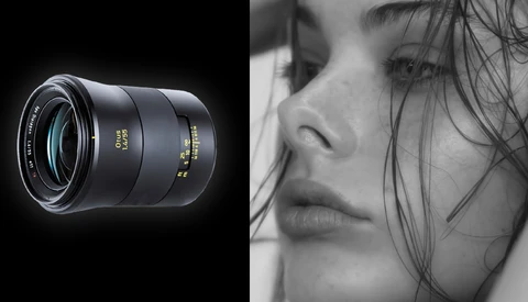 Black telephoto lens with blue glass elements shown against a close-up black and white portrait of a woman's face.