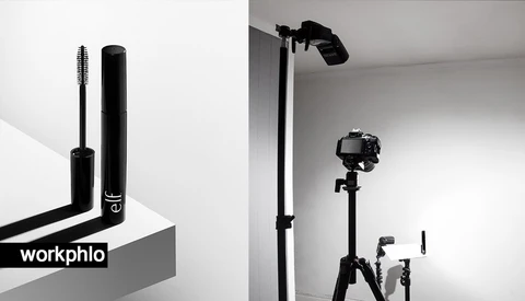 Mascara wand and tube displayed on a geometric surface against a white background.