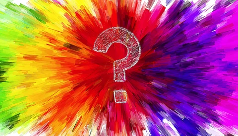 A white question mark centered in a radial burst of vibrant rainbow colors radiating outward.