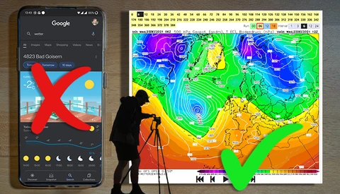 Silhouette of photographer with tripod and telephoto lens next to smartphone and weather map display.