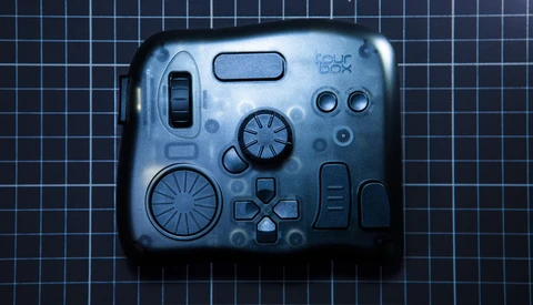 Flat lay of camera controls and mechanical components arranged on grid background.