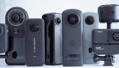 Collection of compact video cameras and action cameras arranged in a line against a white background.