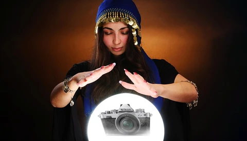 Woman with hands framing glowing camera illustration against warm background.