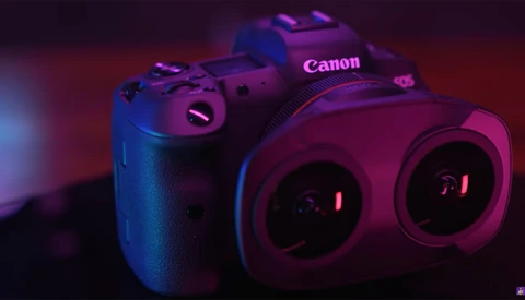Canon DSLR camera photographed against a colorful gradient backdrop with vibrant blue and magenta lighting.