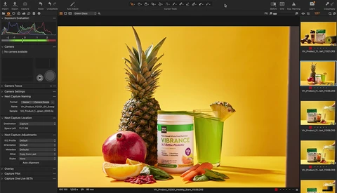 Still life product photography with pineapple, pomegranate, supplement jar, and green cup on yellow background.
