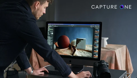 Photographer reviewing still life image on monitor while editing in post-production software.