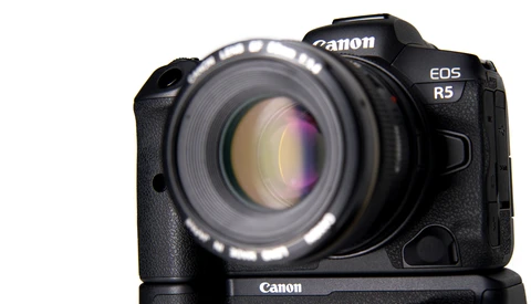 Canon EOS R5 mirrorless camera with standard prime lens mounted, shown from front-facing angle against white background.
