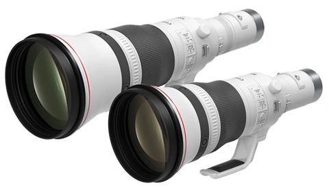 Two white telephoto lenses with black barrels and front elements positioned side by side.