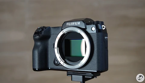 Fujifilm GFX mirrorless camera body with open sensor chamber against neutral background.