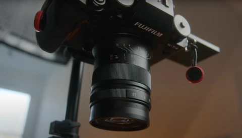 Fujifilm camera mounted on a tripod with a telephoto lens attached, shown in close-up detail.