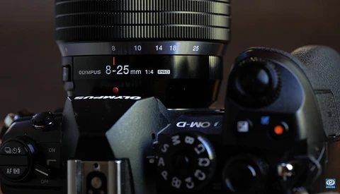Olympus 8-25mm f/1.4 Pro lens mounted on a mirrorless camera body with manual focus ring visible.