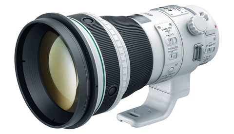 White and black telephoto lens with extended barrel and control rings mounted on camera body.