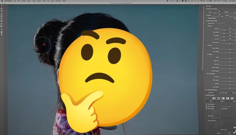 Woman with dark hair holding an oversized yellow emoji face with furrowed brows and hand to chin, conveying a confused or thoughtful expression.