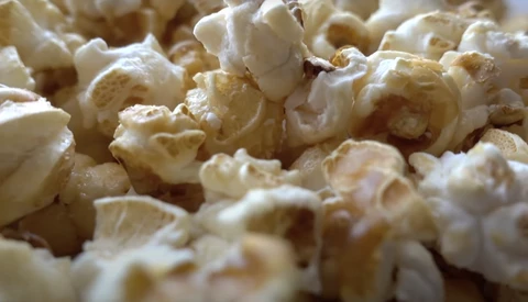 Close-up of freshly popped popcorn with white and golden kernels filling the frame.