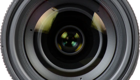 Front-facing view of a camera lens showing concentric glass elements and internal reflections.