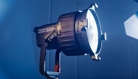Aputure 600D Pro studio light mounted on a stand against a blue backdrop.