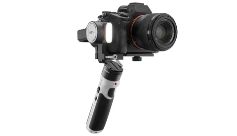 Three-axis motorized gimbal stabilizer with mounted mirrorless camera and telephoto lens.