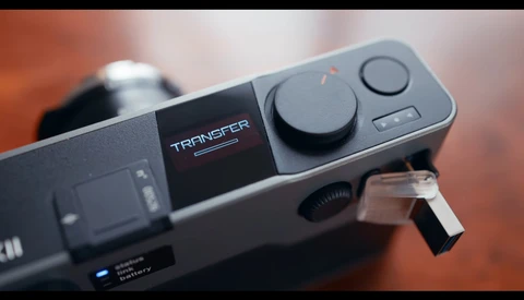 Gimbal stabilizer with control panel showing joystick and mode buttons, with battery indicator visible.