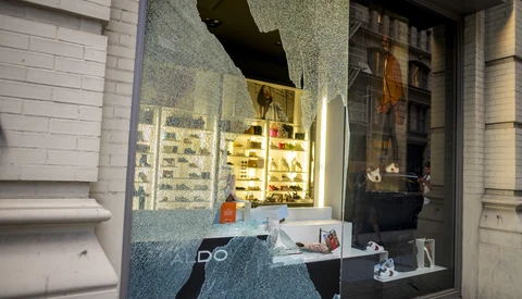 Storefront window display at night with illuminated product shelves and interior lighting reflecting off glass.