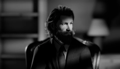 Bearded man in pinstriped suit jacket gazes to the side in black and white portrait.