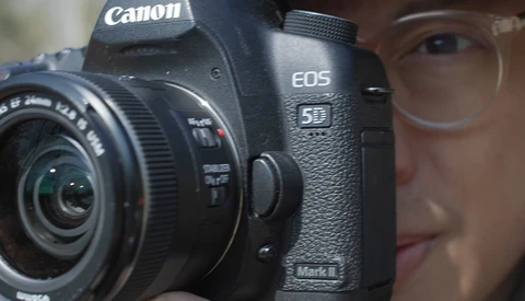 Canon EOS 5D Mark II DSLR camera held up to a person's face during a portrait session.