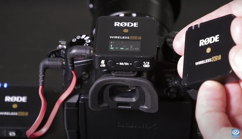 RODE Wireless GO II microphone system with receiver mounted on camera and transmitter held in hand.