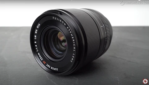 Fujinon XF 18mm f/2 R lens positioned on a gray surface against a neutral background.