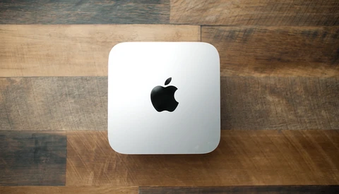 Mac mini desktop computer on wooden surface. Studio product shot.