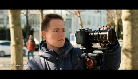 Cinematographer operating a cinema camera on a gimbal in an urban outdoor setting.